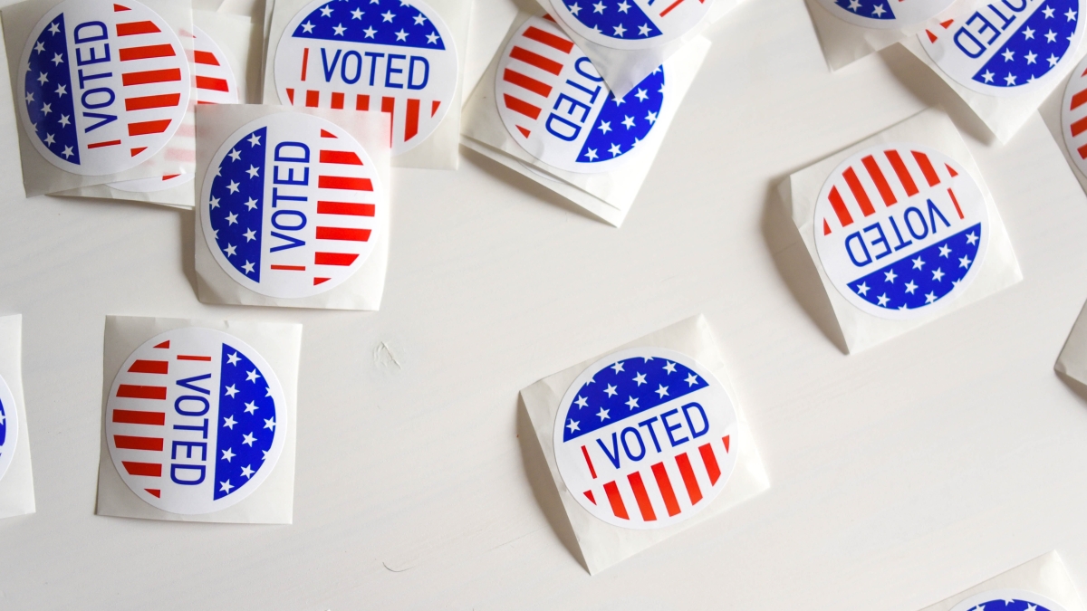 Several stickers that read "I voted" laid out on a table.