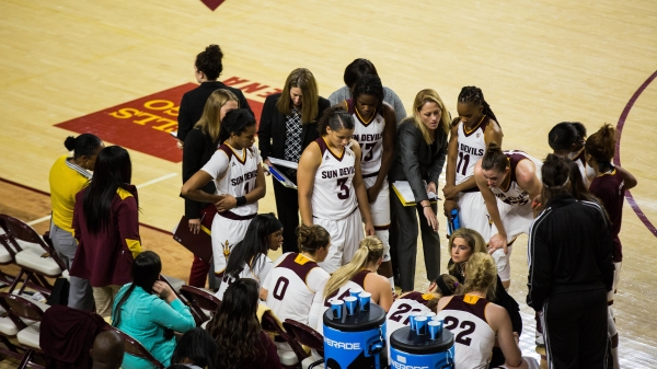 Basketball coach speaking to her players.