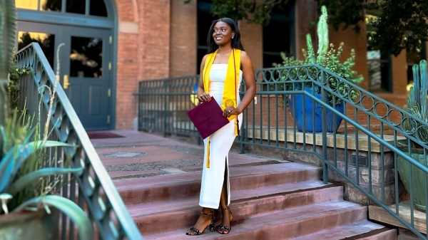 Jasmyn DeGraff posing in graduation regalia