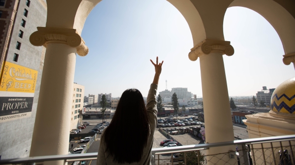 Student uses pitchfork hand on top of building