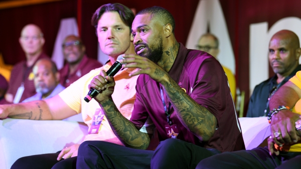 Jaelen Strong addresses a crowd via a microphone while seated