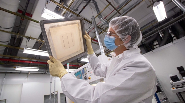 A researcher examines semiconductor material at an ASU MacroTechnology Works lab.