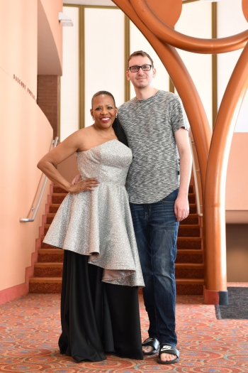 Woman in elegant formal outfit posts with a man in a t-shirt and jeans