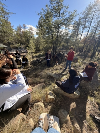 Students gathered together in a forest setting