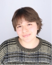 Portrait of a young woman with short brown hair wearing a striped shirt